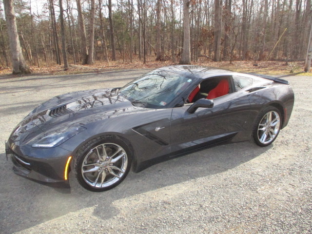 A black corvette parked on the side of a road.
